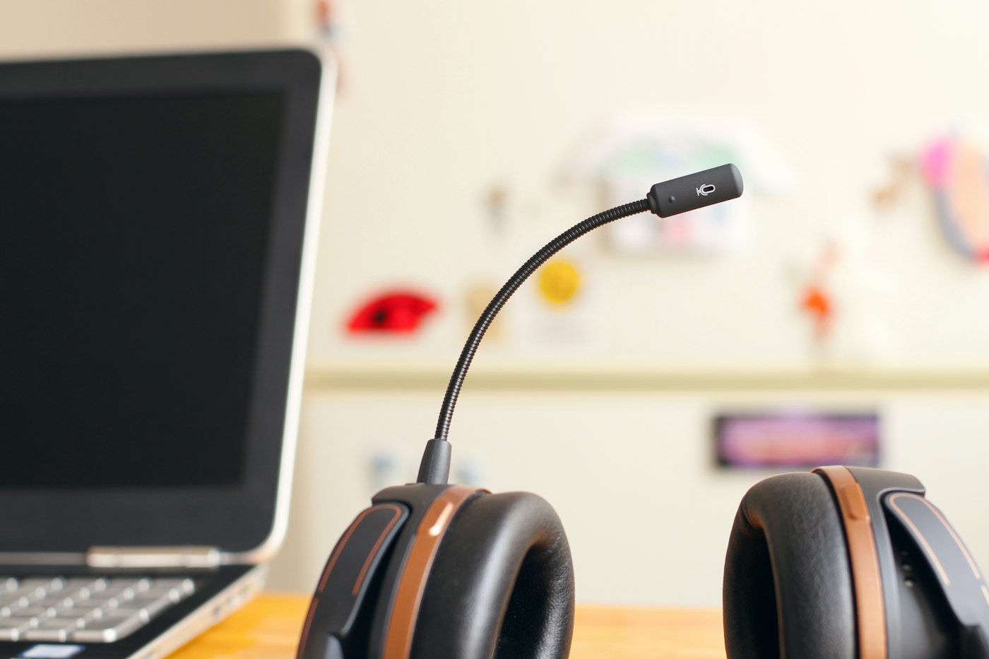 Headphones with a microphone beside a laptop